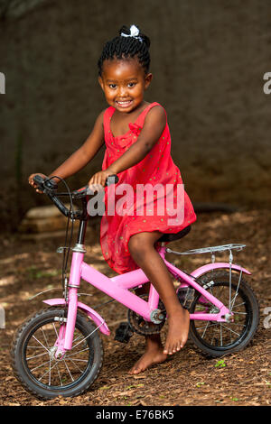 Portrait of African youngster riding cycle outdoors. Stock Photo