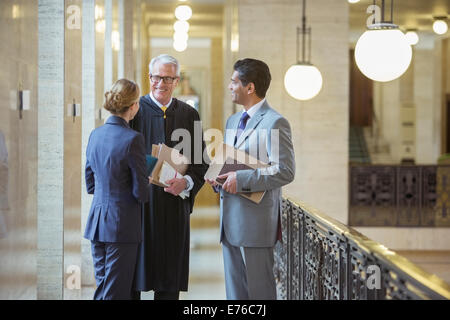Judge and lawyers talking in courthouse Stock Photo