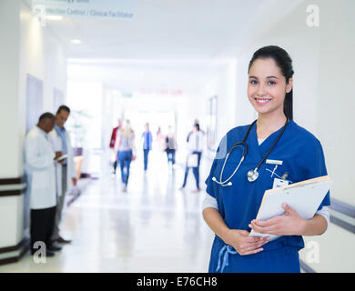 Nurse smiling in hospital hallway Stock Photo