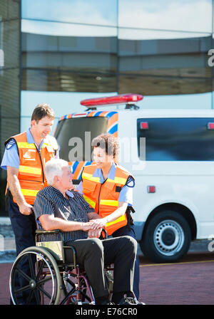 Paramedics greeting patient in wheelchair Stock Photo