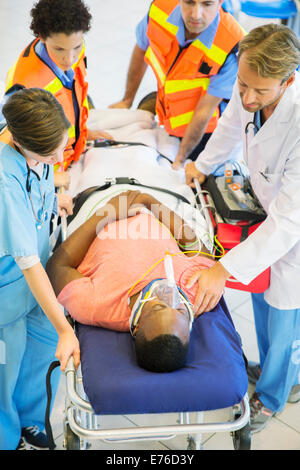 Doctor, nurse and paramedics examining man on stretcher Stock Photo