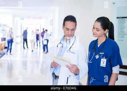 Doctor and nurse reading medical chart in hospital hallway Stock Photo