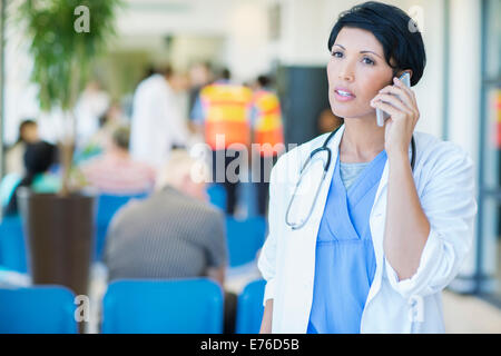 Doctor talking on cell phone in hospital Stock Photo