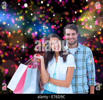 Composite image of happy couple with shopping bags Stock Photo