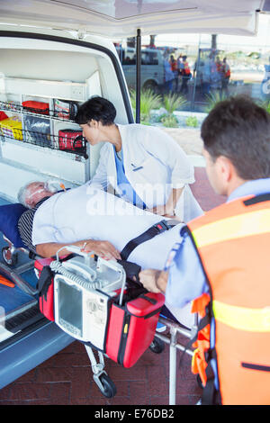 Doctor examining patient on ambulance stretcher Stock Photo