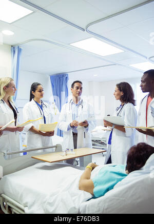 Doctor teaching residents in hospital room Stock Photo