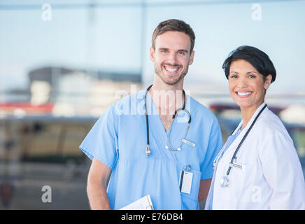 Doctor and nurse smiling outdoors Stock Photo