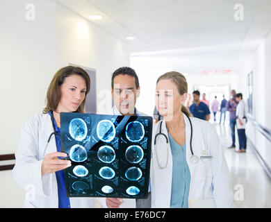 Doctors examining x-rays in hospital hallway Stock Photo