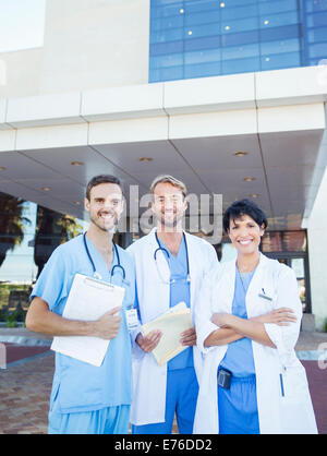 Doctors and nurse smiling outside hospital Stock Photo