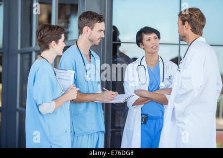 Doctors and nurses talking outside hospital Stock Photo