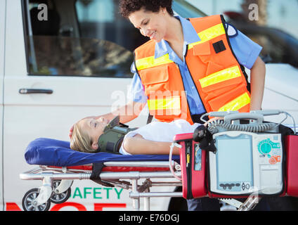 Paramedic examining patient on stretcher Stock Photo