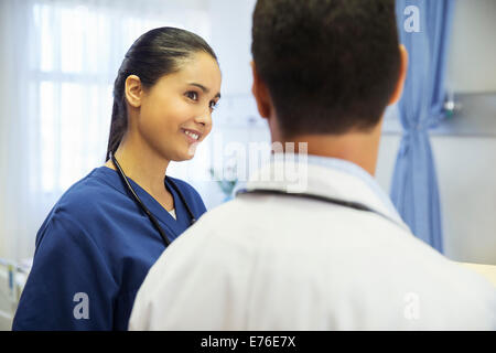 Doctor and nurse talking in hospital room Stock Photo