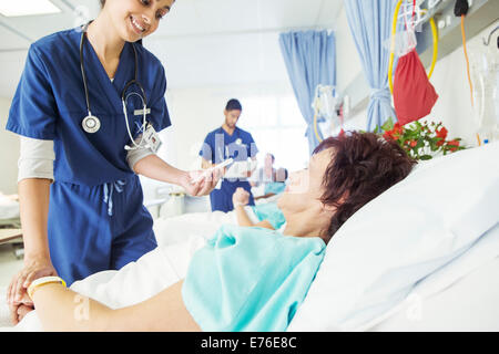 Nurse examining patient in hospital room Stock Photo