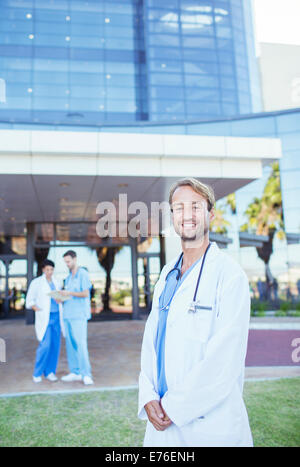 Doctor smiling outside hospital Stock Photo