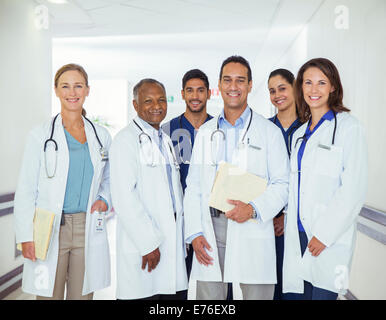 Doctors and nurses smiling in hospital hallway Stock Photo