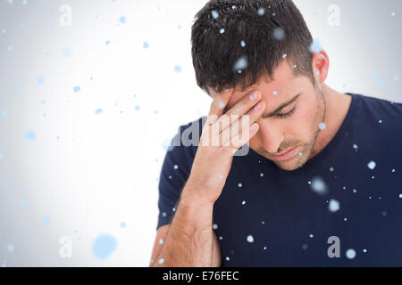 Composite image of upset man standing with his hand holding his forehead Stock Photo