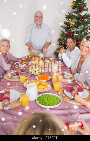 Composite image of happy grandfather carving the christmas turkey Stock Photo