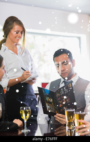 Composite image of businessman ordering a dinner from smiling waitress Stock Photo