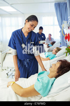 Nurse talking to patient in hospital room Stock Photo