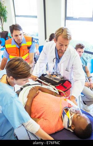 Doctor, nurse and paramedic wheeling patient in hospital Stock Photo