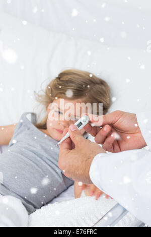Composite image of doctor holding thermometer with ill girl in hospital Stock Photo