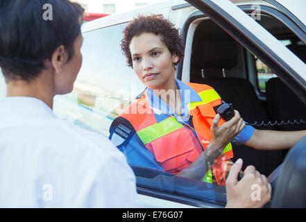 Doctor and paramedic talking outside ambulance Stock Photo