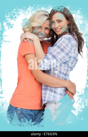 Composite image of two cute friends looking at the camera and hugging Stock Photo