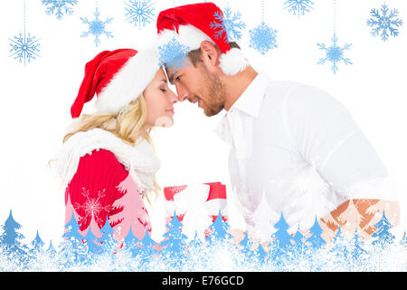 Composite image of festive young couple exchanging presents Stock Photo