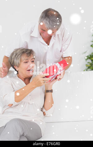 Composite image of husband giving a present to his wife Stock Photo