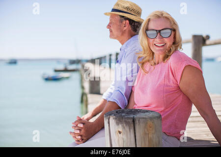 Couple holding hands together on wooden dock Stock Photo