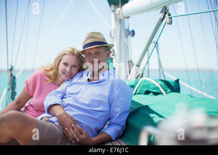 Couple sitting on deck of sailboat Stock Photo