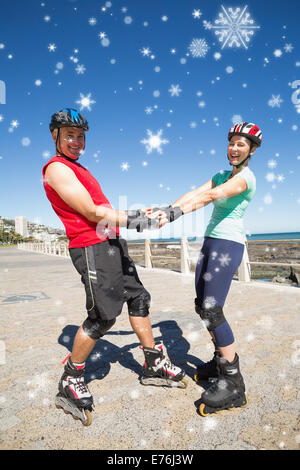 Composite image of fit mature couple rollerblading on the pier Stock Photo
