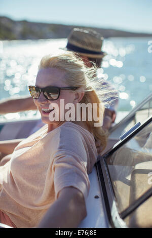 Older woman relaxing in boat with family Stock Photo