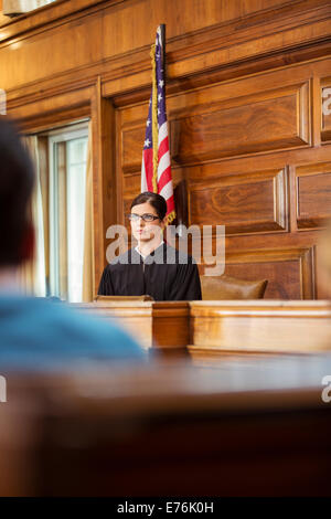 Judge sitting at judges bench in court Stock Photo
