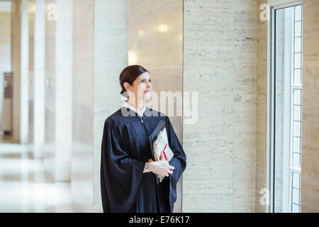 Judge looking out window in courthouse Stock Photo