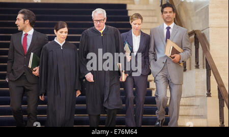 Judges and lawyers walking through courthouse together Stock Photo