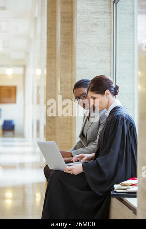 Judge and lawyer working on laptop in courthouse Stock Photo