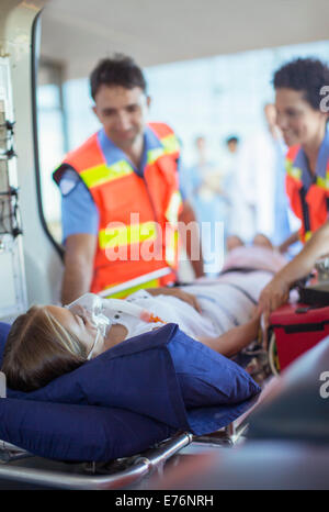 Paramedics examining patient on ambulance stretcher Stock Photo