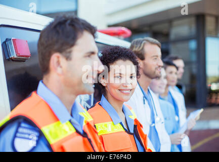 Paramedics, doctors and nurses smiling by ambulance Stock Photo