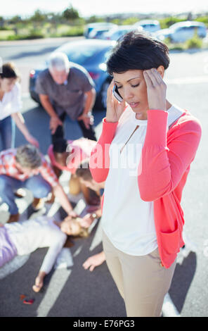 Woman calling emergency services at car accident Stock Photo