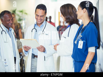 Doctors and nurse talking in hospital hallway Stock Photo