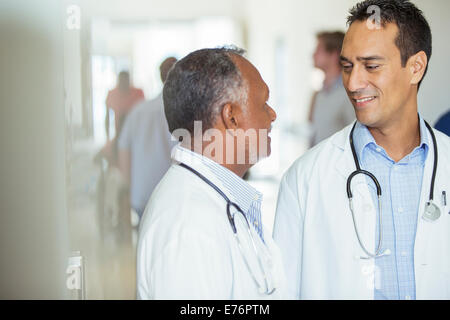 Doctors talking in hospital hallway Stock Photo