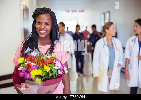 Patient holding bouquet of flowers in hospital Stock Photo