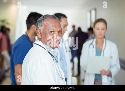 Doctor smiling in hospital hallway Stock Photo