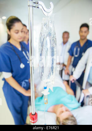 Nurses and doctor wheeling patient in hospital hallway Stock Photo