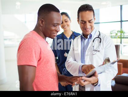 Doctor and patient reading medical chart in hospital Stock Photo