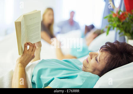Patient reading in hospital room Stock Photo