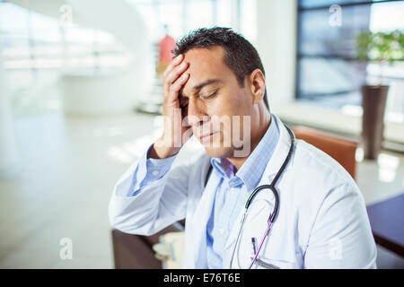 Doctor holding his forehead in hospital Stock Photo