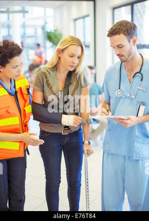 Nurse and paramedic talking to patient in hospital Stock Photo