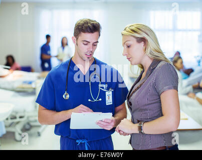Nurse and patient reading medical charts in hospital Stock Photo